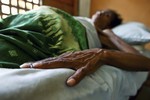 File - HIV/AIDS patient lies in bed at the Bairo Pite clinic for comprehensive community health service, Dili, East Timor.