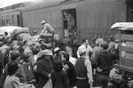 Los Angeles, California. Japanese Americans going to Manzanar gather around a baggage car at the old Santa Fe Station. (April 1942)[59]. Japanese Americans boarding a train bound for one of ten American concentration camps