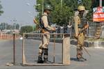 Indian paramilitary soldiers stand guard near barricade during restriction in Srinagar, the summer capital of Indian Kashmir, 21 Sepember 2012. Scores of woman separatist activists of Dukhtar-e-Millat staged a protest against an anti-Islam video. Police fired tear gas to break up the march and detained at least four women. Authorities clamped curfew in old parts of Srinagar while shops and business shut in rest of the city.