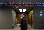 A man walks past a screen showing falling stocks at the Athens Stock Exchange, in red, in Greece on Monday, Feb. 8, 2010. The Greek exchange remained locked in a bear session Monday, with shares falling around 3.7 percent in afternoon trading, even as European stocks rebounded on hopes Greece won't be allowed to default on its crushing debt load. The center-left government is putting the final touches to draft tax reforms meant to boost ailing state coffers, which saw a 12.7 percent budget short