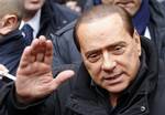 Italian Premier Silvio Berlusconi waves as he arrives at his private residence for a meeting with his allies on possible tax and justice reforms, in Rome, Monday, Jan. 11, 2010.