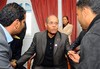 New elected Tunisian President, Moncef Marzoukii, center, speak with unemployed people during the celebration for the first anniversary of the revolution, in Sidi Bouzid, central Tunisia, Saturday, Dec 17, 2011.