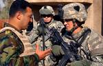 U.S. Army Capt. Thomas Melton, commander of Alpha Troop, 1st Squadron, 75th Cavalry Regiment, 2nd Brigade Combat Team, 101st Airborne Division discusses the day's mission with his counterpart from the 4th Battalion, 1st Brigade, 6th Iraqi Army Division, in Bakariya, Iraq.