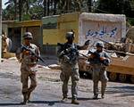 An Iraqi soldier from the 8th Iraqi Army Division and two American Soldiers from 1-30 Infantry, 2nd BCT, 3rd ID, patrol a street in Arab Jabour, Iraq.