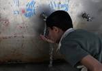 Palestinians filling plastic bottles and jerry cans with drinking water from a public tap at the United Nations Relief and Works Agency (UNRWA) headquarters in the southern Gaza Strip refugee camp of Rafah. -- The Israeli blockade on Gaza has made life more difficult for the inhabitants of the camp. Unemployment levels have increased dramatically, with a large proportion of the residents relying on UNRWA's nutritional and financial assistance.. Photo by AHMED DEEB/WN