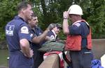 Kentucky River, Kentucky (May 26)--Gulf Strike Team members BM1 Rod Elkins, MK1 Matt Gans, DC1 Ed Daniels and CWO Ray Pitts discuss the placement of pumping equipment aboard a barge in the Kentucky River. The GST was called in to provide technical expertise and equipment when a distillery fire polluted the river. A slug of oxygen-deficient water traveled down the river and killed thousands of fish. The GST pumped air into the water and broke up the water column to re-aerate the water. The Enviro