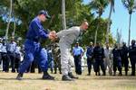 NASSAU, Bahamas - BM3 Ryan Anderson, with the U.S. Coast Guard, demonstrates handcuff procedures on Sgt first class Marlon Paimon from Paramaribo, Suriname, during 'compliant boarding' training for service members from the Royal Bahamas, St. Vincent and Grenadines, St. Kitts-Nevis, Haiti, Trinidad-Tobago, Belize, Barbados and the Dominican Republic Defence Forces at Royal Bahamas Defence Force Base Coral Harbour, March 6. The training is part of Exercise Tradewinds 2009. Tradewinds '09 is a Chai