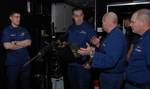 CLEVELAND - Master Chief Petty Officer Patrick O'Kelly, 9th Coast Guard District weapons and ordnance manager, explains to Rear Adm. Michael Parks, 9th District commander, the different scenarios available for a weapons simulator in a portable trailer parked at the Coast Guard's Cleveland Moorings facility, Jan. 24, 2012.The portable trailer is being transported throughout the Great Lakes region to provide weapons training and enhance crew proficiency during the winter months.U.S. Coast Guard ph