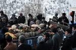 In this Thursday, Dec. 29, 2011 photo, people stand beside the trailer of a tractor carrying the bodies of people mistakenly killed by Turkey's air force, near the Turkish village of Ortasu in Sirnak, Turkey.