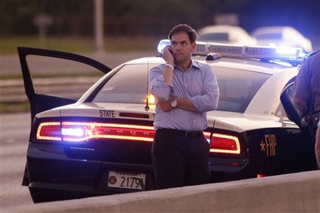 Sen. Marco Rubio, R-Fla., who is traveling with Republican presidential candidate and former Massachusetts Gov. Mitt Romney, uses a phone as he stands alongside Interstate 4 in Lakewood Crest, Fla., Saturday, Oct. 27, 2012 after the motorcade was stopped.