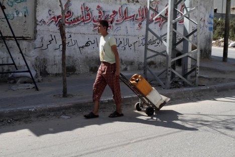 Palestinians filling plastic bottles and jerry cans with drinking water from a public tap at the United Nations Relief and Works Agency (UNRWA) headquarters in the southern Gaza Strip refugee camp of Rafah. -- The Israeli blockade on Gaza has made life more difficult for the inhabitants of the camp. Unemployment levels have increased dramatically, with a large proportion of the residents relying on UNRWA's nutritional and financial assistance.