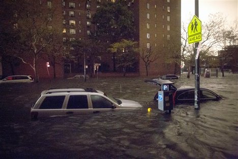 Vehicles are submerged on 14th Street near the Consolidated Edison power plant, Monday, Oct. 29, 2012, in New York.