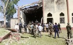 Soldiers stand guards outside St. Rita's Catholic church following a suicide bombing in Kaduna, Nigeria, Sunday, Oct. 28, 2012.