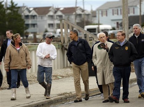 President Barack Obama, center, talks with a local resident as he tours a neighborhood effected by superstorm Sandy, Wednesday, Oct. 31, 2012 in Brigantine, N.J. Walking with Obama are Sen. Frank Lautenberg, D-N.J., and Sen. Bob Menendez, D-N.J., far right.