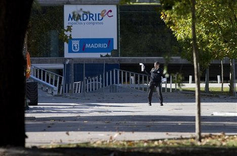 A private security officer tries to avoid an insect in front of the Madrid Arena indoor venue in Madrid, Thursday Nov. 1, 2012.