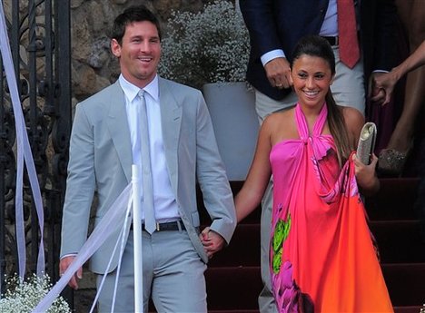 FC Barcelona's Lionel Messi, from Argentina, left, and his girlfriend Antonella Roccuzzo arrive to the Andres Iniesta's wedding at the castle of Tamarit in Tarragona, Spain, Sunday, July 8, 2012.