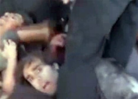 In this frame grab from amateur video taken Thursday, Nov. 1, 2012, and provided by the Syrian Observatory for Human Rights via AP video, captured soldiers lie on the ground in Saraqeb, northern Syria. Later in the video, alleged rebels appear to kill the group of captured soldiers, spraying them with bullets as they lie on the ground.