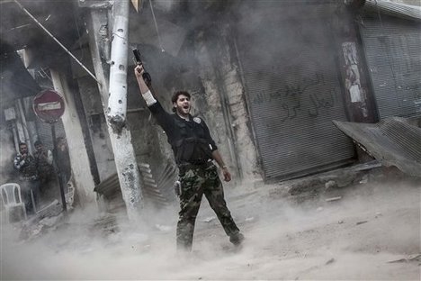 In this Sunday, Nov. 04, 2012 photo, a rebel fighter claims for victory after he fires a shoulder-fired missile toward a building where Syrian troops loyal to President Bashar Assad are hiding while they attempt to gain terrain against the rebels during heavy clashes in the Jedida district of Aleppo, Syria.