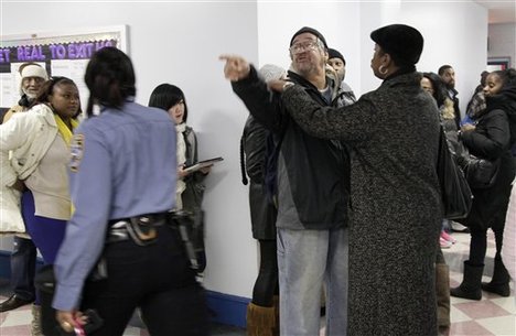 A man waiting to vote at Public School 370 angrily points at a New York City police officer, left, as tempers flare, Tuesday, Nov. 6, 2012 in the Coney Island section of the Brooklyn borough of New York.