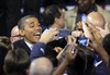 President Barack Obama smiles for cameras as he shakes hands with supporters after speaking at a campaign event at Nationwide Arena