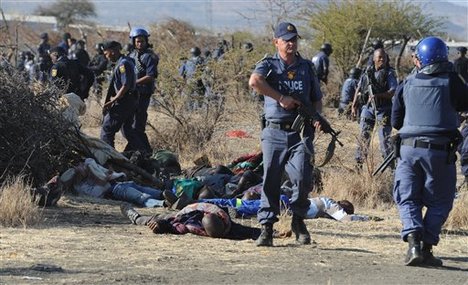 Police surround the bodies of striking miners after opening fire on a crowd at the Lonmin Platinum Mine near Rustenburg, South Africa, Thursday, Aug. 16, 2012.