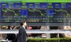 An office worker walks past an electric signboard updating stock indexes in Tokyo, Monday, Dec. 22, 2008. The benchmark Nikkei index rose 121.90 points, or 1.419 percent, to 8,710.42 points in the morning tra