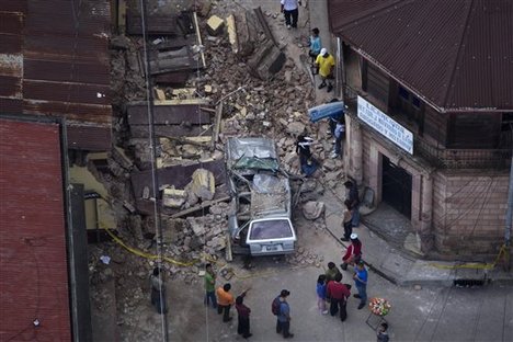 Residents walk among rubble after a magnitude 7.4 earthquake struck in San Marcos, Guatemala, Wednesday Nov. 7, 2012.