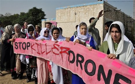 American citizens, hold a banner during a peace march organized by Pakistan's cricket star turned politician Imran Khan's party, not pictured, in Tank, Pakistan, Sunday, Oct. 7, 2012.