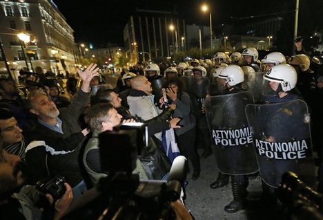 Greek riot police officers, right, push the last remaining protesters off the street, following an anti-austerity rally in front of the Parliament in central Athens, Sunday, Nov. 11, 2012.