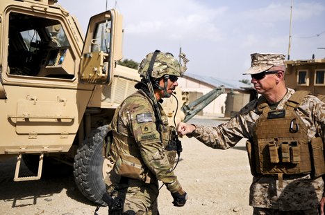 File - Marine Corps Gen. John R. Allen, commander of NATO and International Security Assistance Force troops in Afghanistan, gives a soldier assigned to Forward Operating Base Ghazni a thump on his body armor as he thanked him for his service and sacrifice.