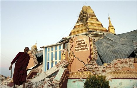 In this photo taken on Monday, Nov. 12, 2012, a Buddhist monk walks in the debris after a pagoda was damaged by a strong earthquake, in Thabeikkyin township in Mandalay, Myanmar.