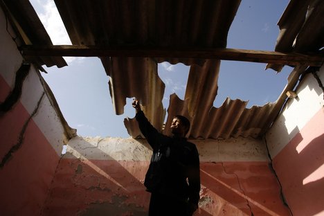 Palestinians inspect the damage to their home following an Israeli military air strike in Rafah town in the southern Gaza Strip on November 11, 2012.