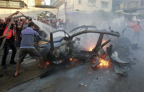 People gather around a wreckage of the car in which was killed Ahmed Jabari, head of the Hamas military wing in Gaza City, Wednesday, Nov. 14, 2012.