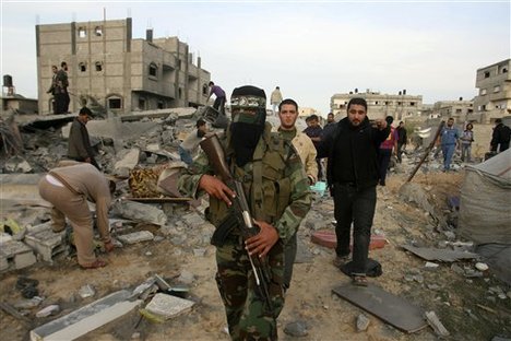 A Palestinian Hamas militant walks in the rubble of the destroyed house of Hamas militant Mohammad Abu Shmala, following an Israeli air strike in Rafah, southern Gaza Strip, Friday, Nov. 16, 2012.