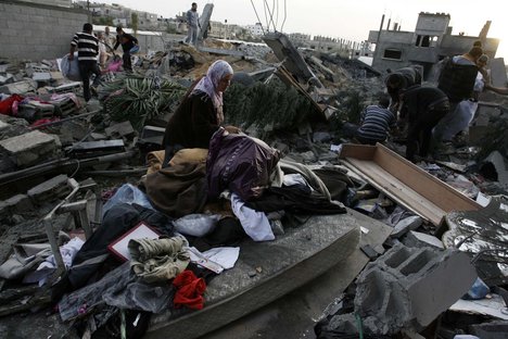 Palestinians inspect damages at a house following Israeli air strikes in Rafah in the southern Gaza Strip on November 16, 2012. Israeli officials said the Jewish state was preparing to launch its first ground offensive in four years into the Gaza Strip, while the army started calling up reservists