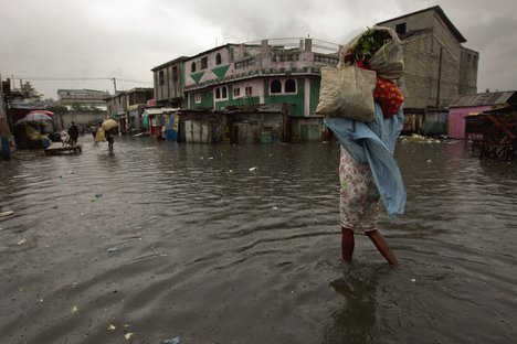 Hurricane Sandy passed to the west of Haiti on 25 October, 2012, causing heavy rains and strong winds, flooding homes and overflowing rivers. A woman walks through a flooded market in Port-au-Prince.