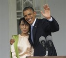 U.S. President Barack Obama, right, waves as he embraces Myanmar's opposition leader Aung San Suu Kyi, left, after addressing members of the media at Suu Kyi's residence in Yangon, Myanmar, Monday, Nov. 19, 2012.