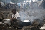 An internally displaced Congolese child heats water at the Mugunga camp outside the eastern Congolese town of Goma, Saturday Nov. 24, 2012.