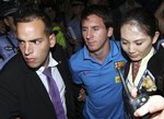 Argentine soccer star Lionel Messi, center, is escorted by officials upon his arrival at the Beijing Capital International Airport in Beijing on Wednesday, Aug. 4, 2010.