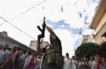 A Syrian gunman shoots in the air during the funeral of 29 year-old Free Syrian Army fighter, Husain Al-Ali, who was killed during clashes in Aleppo, in the town of Marea on the outskirts of Aleppo city, Syria, Thursday, Aug. 9, 2012.