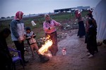 A Syrian family warm themselves at a refugee camp in Azaz, Syria, Monday, Dec 17, 2012.