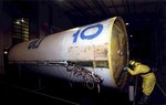 In this released by the South Korean Defense Ministry on Friday, Dec. 21, 2012, taken at unknown location in South Korea, an investigator examines a piece of debris from a rocket launched on Dec. 12, 2012, by North Korea, which was found by the South Korean navy in the Yellow Sea, off Gunsan, South Korea.