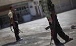 Free Syrian Army soldiers stand guard at a checkpoint in the northern town of Ariha, on the outskirts of Idlib, Syria, Sunday, June 10, 2012.