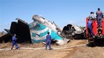 Members of Myanmar Fire Brigade team gather near a damaged Air Bagan passenger plane in Heho, Shan State, Myanmar, Tuesday, Dec. 25, 2012.