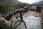 In this Oct. 24, 2012 photo, soldiers stop to check a car as they patrol in a convoy near the town of El Alcalde in Michoacan state, Mexico. Knights Templar, a quasi-religious drug cartel that controls the area and most of the state, monitors the movements of the military and police around the clock.