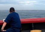 SYDNEY, AUSTRALIA (Mar. 15, 2007)--A crewmember from the Coast Guard Cutter Polar Sea watches the city slip away as the cutter departed from Sydney Harbor.  This was the last time the crew saw land until reaching the Antarctic Continent a week later.  The Polar Sea was in Antarctica as part of Operation Deep Freeze 2007, clearing a navigable channel for supply ships to get needed goods and equipment to personnel working in McMurdo.  USCG photo by PA3 Kevin J. Neff (119154) ( PEOPLE (FOR RELEASE) )