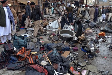 A Pakistani paramilitary soldier and local residents gather at the site of bomb blast in Quetta, Pakistan, Thursday, Jan. 10, 2013.