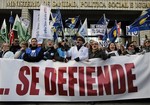 Protestors shout slogans as they carry banners reading, "Health care system…defend it!", partly seen, during a demonstration against regional government imposed austerity plans to restructure and part privatize health care sector in Madrid, Spain, Sunday, Jan. 13, 2013. Madrid proposes selling off the management of six of 20 public hospitals and 27 of 268 health centers. Spain's regions are struggling with a combined debt of 145 billion euro ($190 billion) as the country's economy contracts into a double dip recession triggered by a 2008 real estate crash.