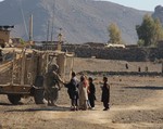 File - Sgt. David Seay, 3rd Brigade Combat Team "Rakkasans," 101st Airborne Division (Air Assault), interacts with children of the small Khowst District village during an humanitarian aid distribution mission near Forward Operating Base Salerno, Afghanistan, Dec. 10, 2012.