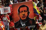 A supporter of Venezuela's President Hugo Chavez holds up a painting of him during a symbolic inauguration rally for Chavez outside Miraflores presidential palace in Caracas, Venezuela, Thursday, Jan. 10, 2013.